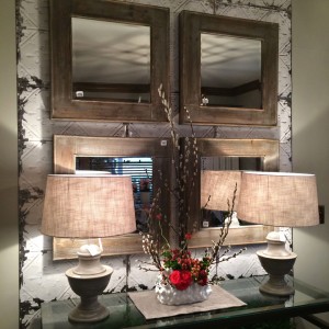 Layered wall display with mirrors and tin panel.